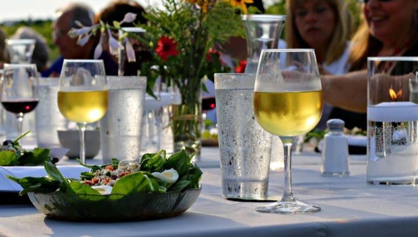 Bottle and glasses of white wine on a festive outdoor dining table